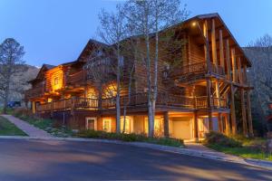 a large wooden house with a balcony on a street at Rock Creek Resort in Red Lodge