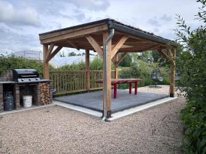 a wooden gazebo with a picnic table and a grill at Red Sheds Cabin 'Herons Den' in Portarlington +5 photos