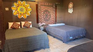 a room with two beds and a painting on the wall at Suítes icarai vila in Caucaia