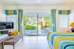a bedroom with a bed and a view of a patio at Antigua Village Beach Resort in Saint Johnʼs