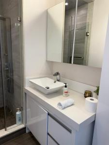 a white bathroom with a sink and a mirror at Modern House in Toronto in Toronto