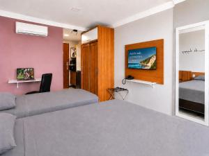 a bedroom with a bed and a mirror at Flat vista Mar -conforto e estilo em Ponta Negra-Natal in Natal