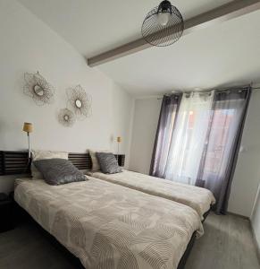 a bedroom with two beds and a large window at L Olivier in Nanterre