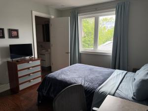 a bedroom with a bed and a dresser and a window at Modern House in Toronto in Toronto