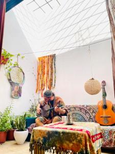 a man sitting on a couch playing a guitar at Dar D'Art in Tunis