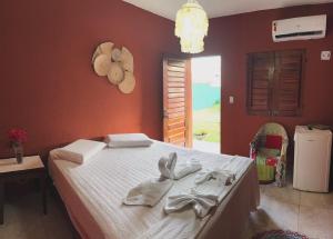a bedroom with a bed with towels on it at Suítes icarai vila in Caucaia +8 photos