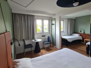 a hotel room with a bed and a table and chairs at ibis Vannes in Vannes