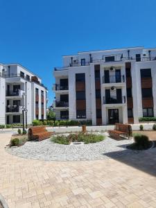 two apartment buildings with benches in front of them at Altura Garden 1 in Vrnjačka Banja