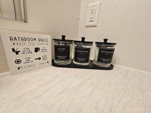 three containers of bathroom fluids sitting on a shelf next to a wall at Southern Charm on Earl in Stanfield +24 photos