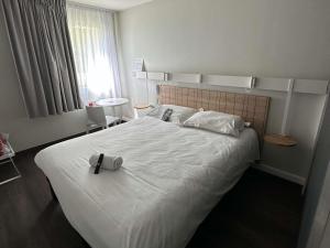 a bedroom with a bed with a cross on it at ibis Abbeville in Abbeville +55 photos