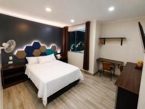 a bedroom with a bed and a desk and a piano at Hospedaje Diamantes in Huacho +14 photos