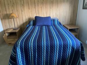 a bedroom with a bed with a blue comforter at Gravel Road Getaway in Hermiston