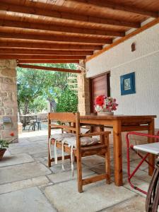 a wooden table and chairs on a patio at Egina Home in Egina