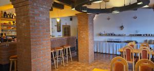 a room with a bar with stools and a brick wall at Penzion Bernardýn in Bořetice