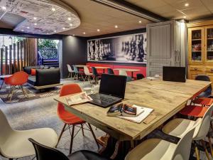 a conference room with a table with a laptop on it at ibis Lyon Nord in Dardilly