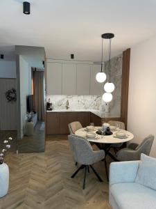 a living room with a table and chairs and a kitchen at Casella Apartment E34 Let's Sea Baltic Park in Gąski