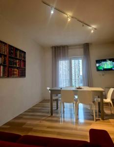 a dining room with a table and chairs and a television at Le Caravelle in Mestre