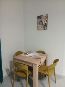 a table with four chairs and a picture on the wall at Dolcecasa in Misilmeri