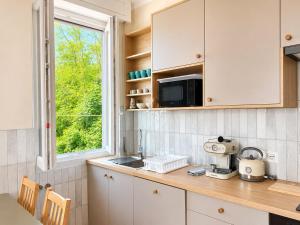 a kitchen with white cabinets and a sink and a window at Panorama - Lake Maggiore House in Colazza