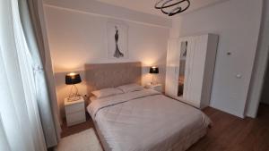 a bedroom with a white bed and two lamps at Cristina Home in Alba Iulia