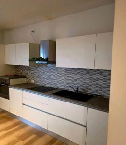an empty kitchen with white cabinets and a sink at Le Caravelle in Mestre