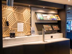 a counter in a store with a wooden wall at Mercure Lorient Centre in Lorient