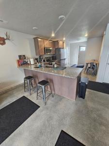 a kitchen with a counter and stools in a room at Cozy 2BR Home Parking Full Kitchen in Stanfield