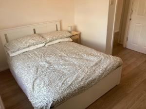 a bedroom with a bed with a silver comforter at Chestnut Villa in Epsom