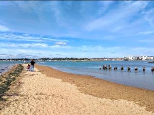a man and a child standing on a beach at Point Clear 4 bed Static Caravan in Saint Osyth