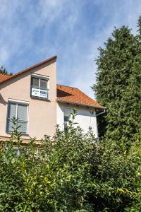 a building with a balcony and a tree at Dollár Apartman in Orfű +5 photos