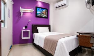 a bedroom with a purple wall and a bed at Hospedaje Diamantes in Huacho