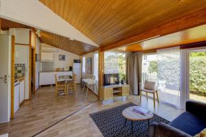 a living room with a couch and a table at Comfortable chalet in a vacation village in Gujan-Mestras