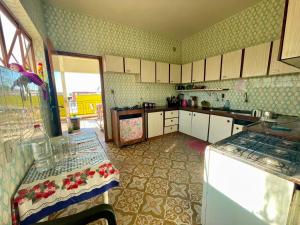 a kitchen with white cabinets and a table in it at POUSADA OCZ Centro1 in Osvaldo Cruz