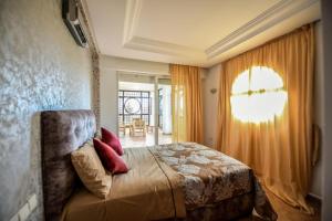 a bedroom with a bed and a window at Spacious apartment, pool, beach, basement parking in Bouznika +17 photos