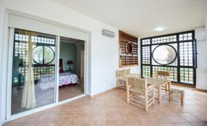 a room with a table and chairs and a bedroom at Spacious apartment, pool, beach, basement parking in Bouznika