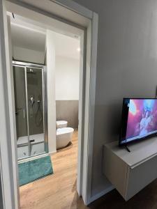 a bathroom with a television and a bathroom with a toilet at Urban Apartments RE in Reggio Emilia