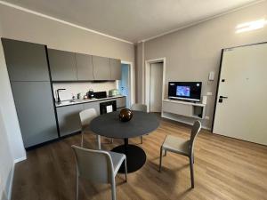 a room with a table and chairs and a kitchen at Urban Apartments RE in Reggio Emilia