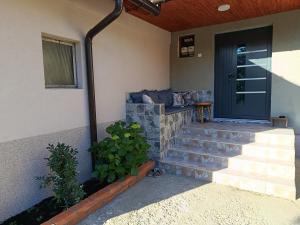 a front porch with stairs and a blue door at Kuća - Šekovići in Šekovići +48 photos