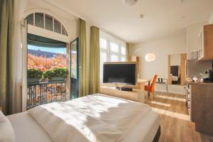 a bedroom with a large bed and a large window at Apartmenthotel Kaiser Karl in Bonn