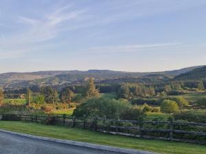 a fence on the side of a road with mountains in the background at Apartment in Coolea in Bard Inch
