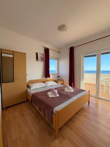 a bedroom with a bed with a view of the ocean at Apartmani "Nikola" Seaview - Ivan Dolac, Hvar in Ivan Dolac