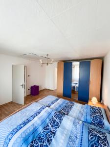 a bedroom with a large bed with blue sheets at House Flajs - secluded 2BR Surrounded by Forest in Soča