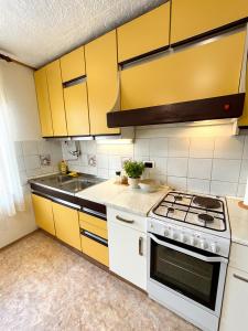 a kitchen with yellow cabinets and a stove at House Flajs - secluded 2BR Surrounded by Forest in Soča +9 photos