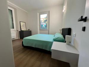 a bedroom with a green bed and a window at Urban Apartments RE in Reggio Emilia