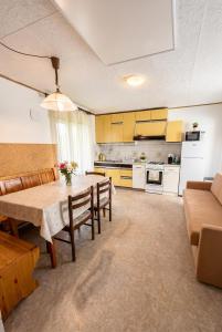 a dining room and kitchen with a table and chairs at House Flajs - secluded 2BR Surrounded by Forest in Soča
