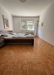 a bedroom with a bed and a wooden floor at Ruhig und gemütlich in Graz