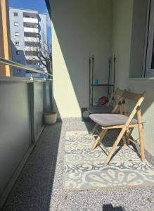 a room with a chair and a rug on a balcony at Ruhig und gemütlich in Graz