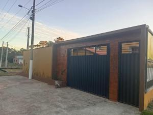 eine Garage mit schwarzem Tor und ein Gebäude in der Unterkunft Refúgio Gamboa in São Francisco do Sul