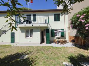a white house with a balcony and a table at Da Zia Vecchia 1 in Cervia