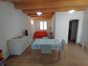 a dining room with a table and a red couch at Da Zia Vecchia 1 in Cervia